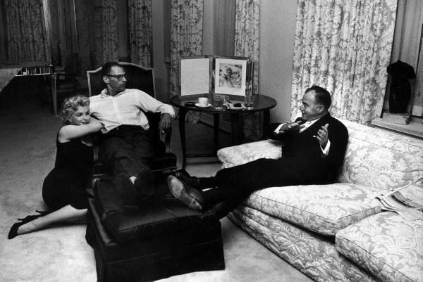 Producer Kermit Bloomgarden (R) visiting with playwright Arthur Miller (C) & his wife Marilyn Monroe, in their apartment. Circa 1958.